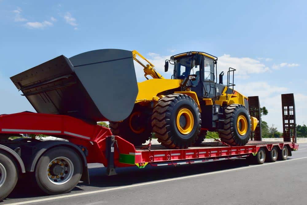 Transporting a bulldozer usine a tilt tray tow truck in Alice Springs